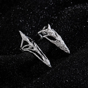 Gothic silver skeletal claw ring with intricate bone structure on black glitter background