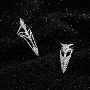 Detailed macro of silver gothic skeleton rings with white zircons on dark background