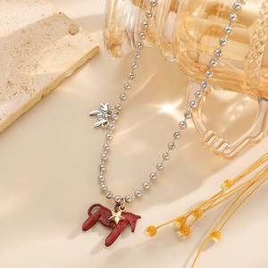 Detail der roten Emaille Pony-Anhänger und Silberperlenkette mit ästhetischem Hintergrund