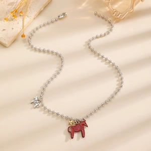 Detailaufnahme der Perlenkette mit rotem Pony und goldenem Stern Anhänger