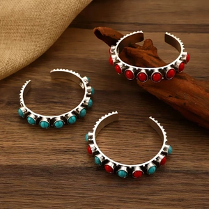 Bohemian vintage open cuffs with turquoise and red coral stones on a wooden background