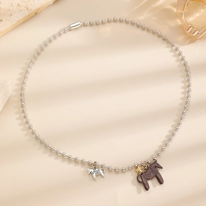 Detail einer silbernen Kugelkette mit braunem Pony und hohlem Pferde-Anhänger