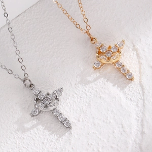 Macro shot of gold and silver crown cross necklaces with sparkling cubic zirconia stones