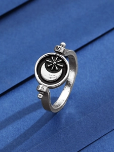 Dettaglio dell'anello rotante vintage con motivi celesti di sole e luna in argento