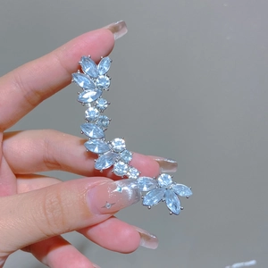 Macro detail of silver-tone ear cuff with micro-paved zircons in leaf design
