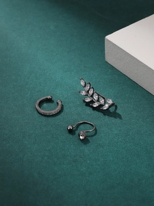 Detailed view of gunmetal geometric ear cuffs and studs with cubic zirconia and heart charms