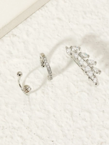 Detailed set of silver zircon floral ear cuff and leaf ear crawler on white background