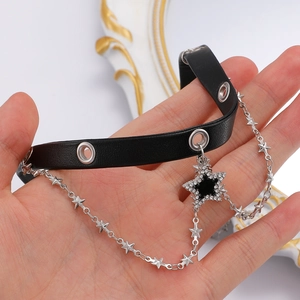 Close-up of black leather choker with silver grommets and starry crystal pendant