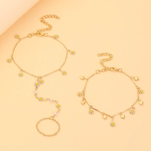 Detail von vergoldetem Gänseblümchen-Armband-Set mit rosa Perlen und Herzanhängern