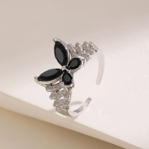 Macro detail of silver-tone butterfly open ring featuring black stones and pavé diamonds