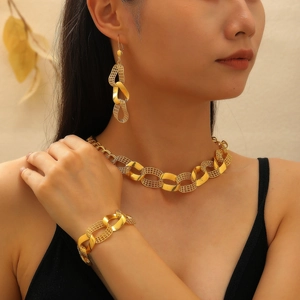 Gouden grove ketting sieradenset met ketting armband en oorbellen op een model