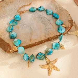 Dettaglio macro della collana oceanica con stelle marine dorate e perline turchesi