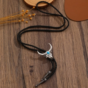 Detail einer silbernen Bullenkopf Bolo Tie mit Türkis auf antikem Holzhintergrund