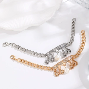 Detailed macro of gold and silver charm bracelets with LOVE plates and pearls