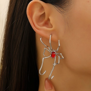 Detailed close-up of a silver spider ear cuff featuring a vibrant red oval gemstone