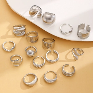 Makro-Detail von 16-teiligem silbernem geometrischem Ringset mit glatten Lavalinien