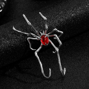 Detailed close-up of a silver spider ear cuff with a vibrant red oval gemstone