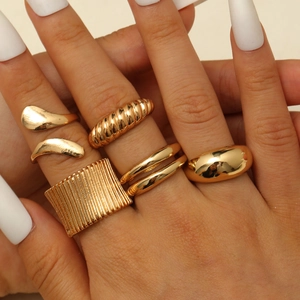 Makroaufnahme polierter goldener geometrischer Ringe mit Struktur- und Spiral-Details