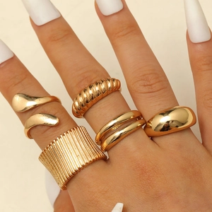 Nahaufnahme von fünfteiligem vergoldetem Ringset mit minimalistischen Designs