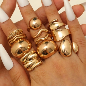 Nahaufnahme eines vergoldeten Ring-Sets mit Lava-Linien und runden geometrischen Details