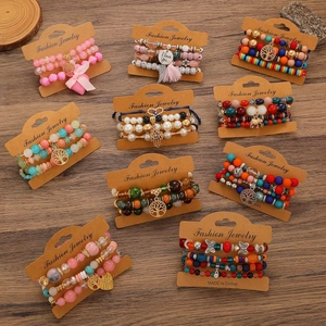Boheems gelaagd kralenarmbandenset met metalen bedeltjes op een vintage houten achtergrond