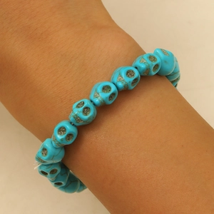 Détail d'un bracelet de perles crânes turquoise aux motifs naturels sur un poignet