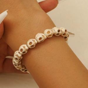 Vue détaillée d'un bracelet en perles de crâne avec texture de pierre vintage au poignet