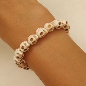 Gros plan d'un bracelet de perles de crâne blanc avec des détails marron rétro