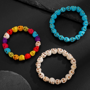 Bracelets de perles crânes gothiques en multicolore, bleu ciel et ivoire sur pierre noire