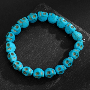 Gros plan détaillé du bracelet en perles de crâne turquoise sur une pierre noire mate