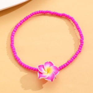 Primer plano de tobillera de cuentas rosas con detalle de flor de plumeria de resina