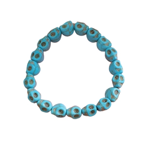 Détails des perles crânes avec yeux scintillants argentés sur un bracelet turquoise bleu