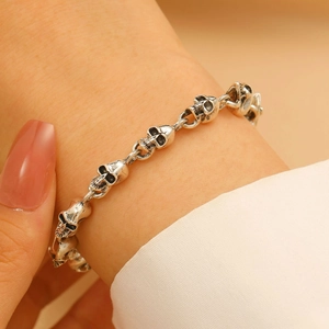 Nahaufnahme eines Vintage-Silber-Totenkopf-Armbands im Gothic-Design am Handgelenk