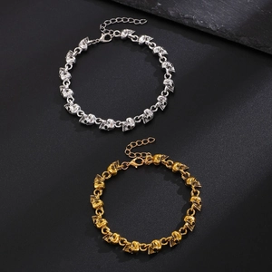 Detailansicht der goldenen und silbernen Totenkopf-Armbänder mit verstellbarem Verschluss