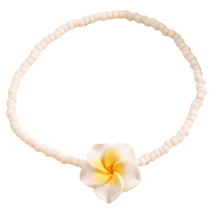 Detalle de la tobillera bohemia con cuentas blancas mate y colgante de flor de frangipani