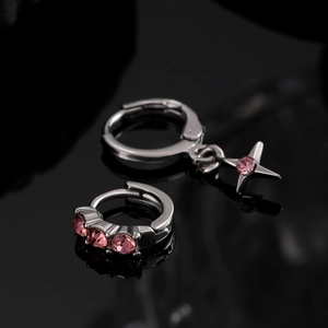 Silver star hoop earrings with pink zircons on a sleek black reflective background