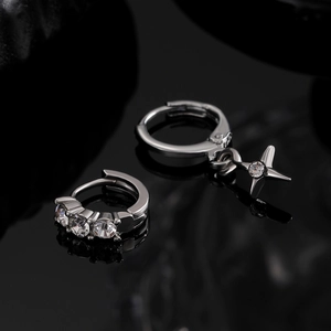 Macro shot of silver hoop earrings with clear cubic zirconia and star pendant detail