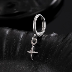 Macro shot of silver hoop earring with star pendant and small clear cubic zirconia