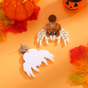 Λεπτομέρεια από σκουλαρίκια αράχνης Halloween με μαρμάρινη υφή σε πορτοκαλί φόντο