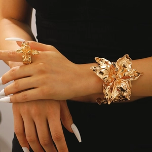 Dettaglio ravvicinato del set di gioielli a fiore dorato con anello e bracciale