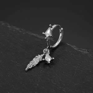 Macro shot of silver hoop earring with feather pendant and clear kite-shaped gemstones
