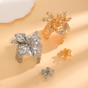 Dettaglio di un set di bracciale rigido e anello con grandi fiori 3D in oro e argento