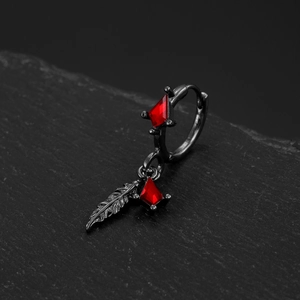 Macro shot of gothic black hoop earrings with red zircon and feather pendant charms