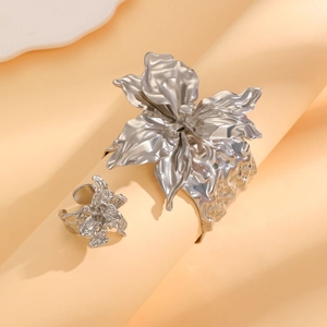 Dettaglio di parure di gioielli floreali 3D argento con bracciale rigido e anello