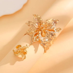 Vista dettagliata del bracciale rigido a fiore dorato scolpito e set di anelli coordinati
