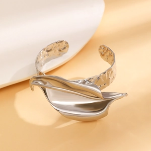 Dettaglio del bracciale aperto in argento con design a foglia e finitura martellata