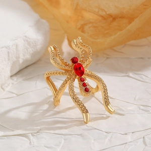 Vue rapprochée d'une bague araignée dorée sertie de rubis rouges et cristaux