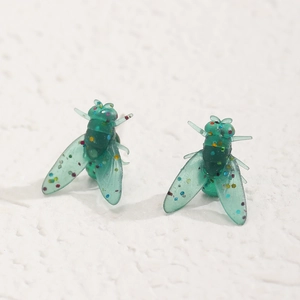 Dettaglio di orecchini a mosca in resina verde con paillettes colorate e finitura lucida