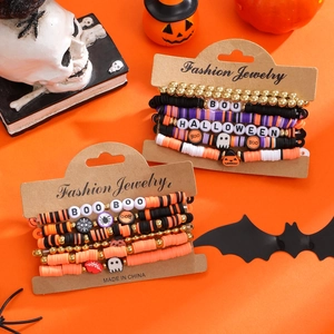 Detailed view of Halloween beaded bracelets with ghost and pumpkin charms on a card