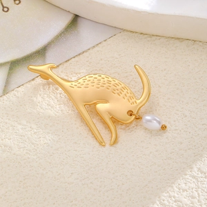 Detail of golden deer brooch with matte texture and elegant teardrop pearl pendant